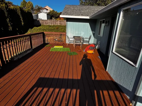 Before and after: a tan house re-sided in green with white trim