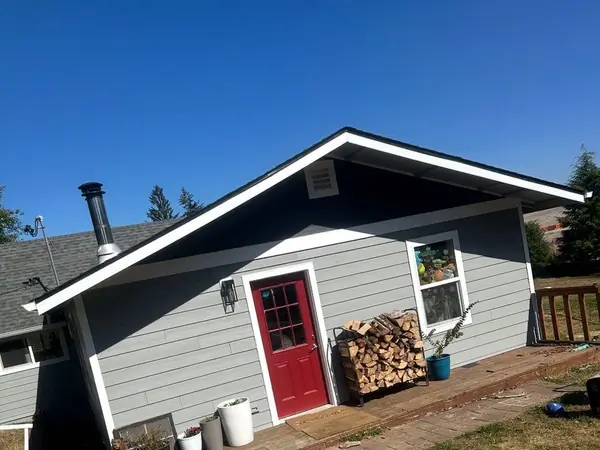 Blue-gray house with new James Hardie siding, white trim and a red door