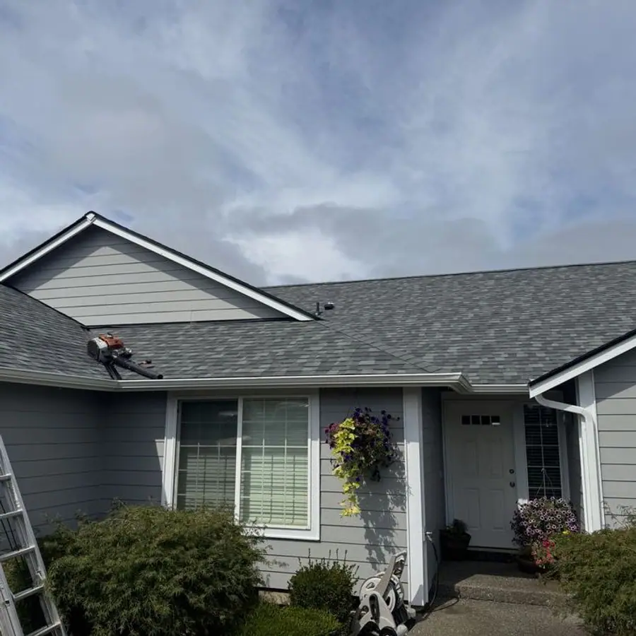 New gray shingle roof with valleys under a blue sky