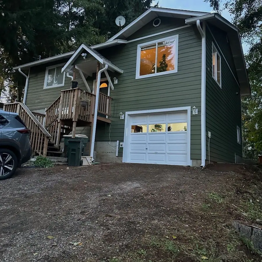Two-story house with new green lap siding and white trim